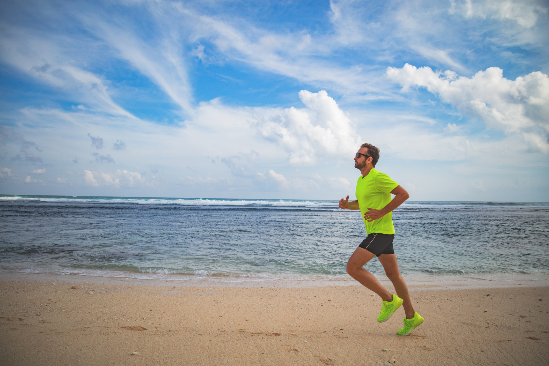 Jogging on a tropical sandy beach near sea / ocean.